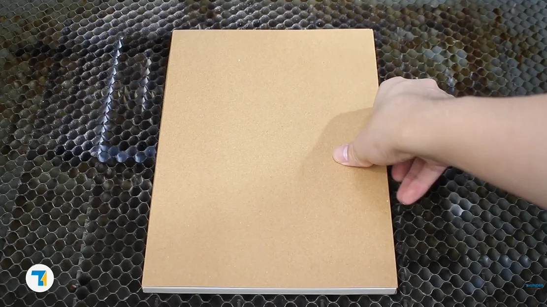 put the kraft paper notebook on the laser bed.webp